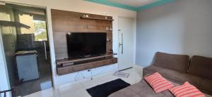 a living room with a couch and a flat screen tv at Apartamento Mobiliado, Parque Atheneu. in Goiânia