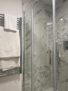 a bathroom with a shower with a glass at Peak Willow Apartments in Leek