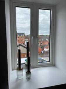 a window with two vases sitting on a window sill at Peak Willow Apartments in Leek