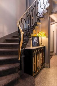 a staircase with a black iron railing and a lamp at Hôtel des Ecrivains in Paris