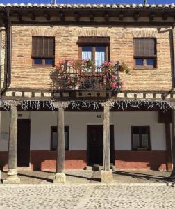 a building with a balcony with flowers on it at Casa Histórica Aldana, Plaza Vieja in Saldaña