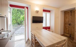 uma cozinha com uma mesa de madeira e uma grande janela em La primula della Valle Soana em Ronco Canavese