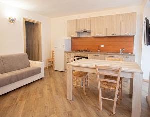 a kitchen and living room with a table and a couch at La primula della Valle Soana in Ronco Canavese