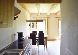 a kitchen with a table and chairs in a room at Ferienhof Forstmoar in Gars am Inn