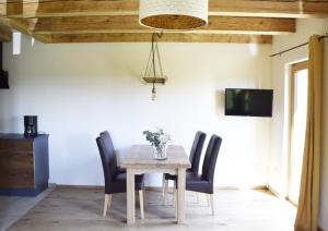 uma sala de jantar com uma mesa de madeira e cadeiras pretas em Ferienhof Forstmoar em Gars am Inn
