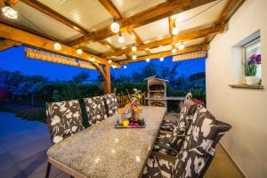 een terras met een tafel en stoelen onder een pergola bij Leonardo House in Novigrad Istria