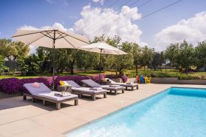 een zwembad met ligstoelen en een parasol naast een zwembad bij Leonardo House in Novigrad Istria