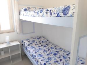 a bedroom with two bunk beds with blue and white flowers at Overlooking the sea Santa Teresa Gallura in Santa Teresa Gallura +16 photos