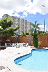 una piscina en un complejo con mesas y sillas en Golden Dolphin Express, en Caldas Novas