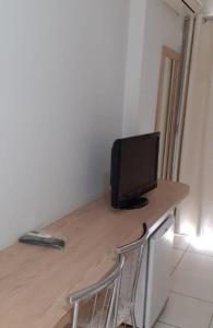 un monitor de ordenador sobre un escritorio de madera en Golden Dolphin Express, en Caldas Novas