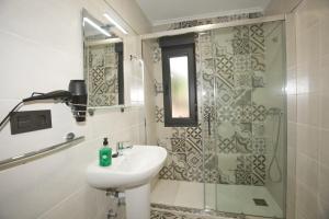 a bathroom with a sink and a shower at Apartamentos La Cueva - Onis in Avín