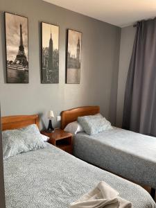 a bedroom with two beds and pictures on the wall at Hostal La Concha Somo in Somo +61 photos