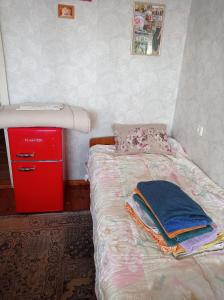 a small bedroom with a bed and a red cabinet at Tirgus iela 2 in Krāslava