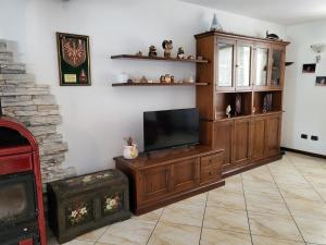 a living room with a flat screen tv and a entertainment center at Appartamento Gobi in Castel Condino