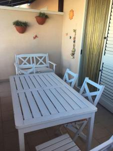 einen weißen Tisch und zwei Stühle auf einer Veranda in der Unterkunft Casa stella marina in Campomarino