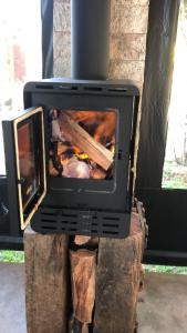 a television sitting on a stump with a fireplace at Campos House in Campos do Jordão