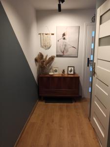 korytarz z drewnianą podłogą i dwoma obrazami na ścianie w obiekcie Uroczy apartament nad morzem Gdańsk w Gdańsku