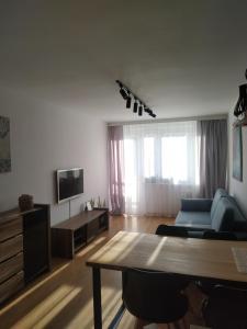 a living room with a blue couch and a table at Uroczy apartament nad morzem Gdańsk in Gdańsk