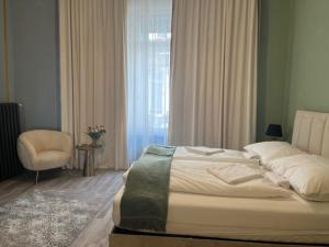 a bedroom with a bed and a chair and a window at W Urban Suites Budapest in Budapest