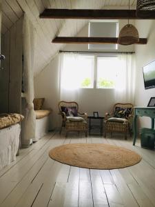 uma sala de estar com cadeiras e um tapete no chão em Galleriet BnB em Stenkyrka