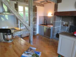 a kitchen with a table and a counter top at La Demeure de Cyr in Saint-Chamant