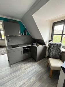 a small kitchen with a sink and a chair at Exklusive Ferienwohnung nahe der Nordsee in Wesselburen