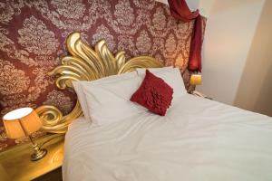 a bed with a gold headboard and a red pillow at G Boutique Hotel in Portsmouth +112 photos
