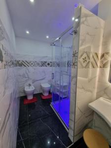 bagno con doccia in vetro e servizi igienici di Piazza Colombo-Apartments a Sanremo