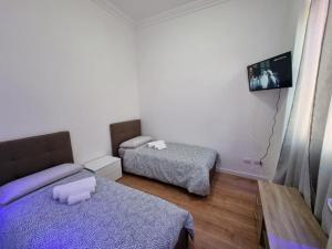 a small room with two beds and a tv at Piazza Colombo-Apartments in Sanremo