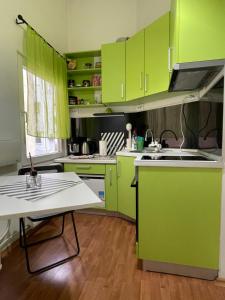 a kitchen with lime green cabinets and a table at ATA Apartment in Skopje