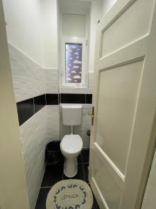 a small bathroom with a toilet and a window at ATA Apartment in Skopje +30 photos