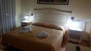 una camera da letto con un letto e due asciugamani di Hotel Siros a Verona
