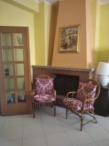 - deux chaises dans une pièce avec cheminée dans l'établissement Casa Carlo&Luisa, à Pescara
