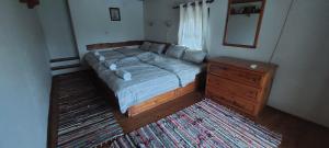 1 dormitorio con cama, tocador y espejo en СЪНТОВЕЦ - къща за гости, en Asparukhovo