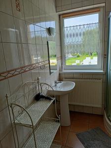 baño con lavabo y ventana en Anna, en Czarny Młyn