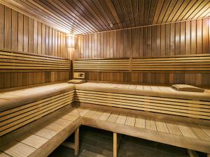 an empty sauna with wooden walls and benches at Apartman Residence Moser 1504 in Karlovy Vary