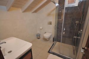 a bathroom with a shower and a toilet and a sink at Brothers Cesme Hotel in Cesme +28 photos