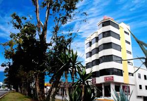 um edifício branco e amarelo ao lado de uma rua em HB Express Hotel em Tlaxcala de Xicohténcatl