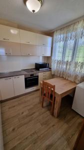 cocina con mesa de madera y suelo de madera en Родопска къща за гости с.ЧАЛА en Chala