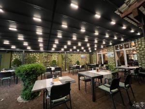 a restaurant with tables and chairs and lights at Hotel am Rathaus Adii in Tangermünde