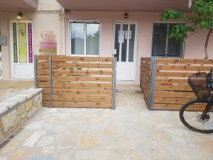a wooden fence in front of a house with a bike at Limonero New City Apartment 1 with Private Parking in Lefkada Town