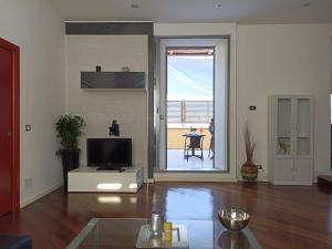 a living room with a television and a living room with a table at Attico Gabriel in Civitavecchia