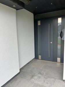 a hallway with a blue door and a tile floor at Exklusive Ferienwohnung nahe der Nordsee in Wesselburen
