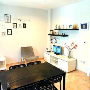 uma sala de estar com uma mesa e uma cadeira em Bianca em Valência