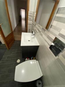 uma casa de banho com um lavatório branco e um WC. em La casa di Gianfry em Paola