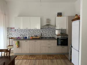 a kitchen with white cabinets and a stove top oven at La casa di Gianfry in Paola