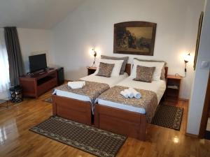 Wellness B&B Winery Sontacchi في Kutjevo: غرفة نوم بسريرين عليها مناشف