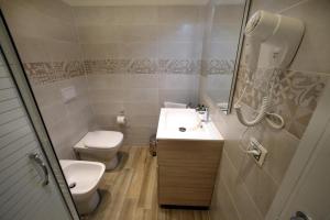 un bagno con lavandino, WC e specchio di FLORENCE ROOMS67 a Firenze Altre 16 foto