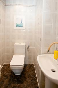 een badkamer met een wit toilet en een wastafel bij Uroczy Apartament Rzeczna Kołobrzeg in Kołobrzeg