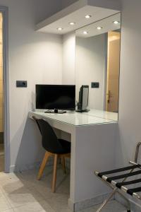 a desk with a chair and a mirror on a wall at Asteri Studios in Kalamaki